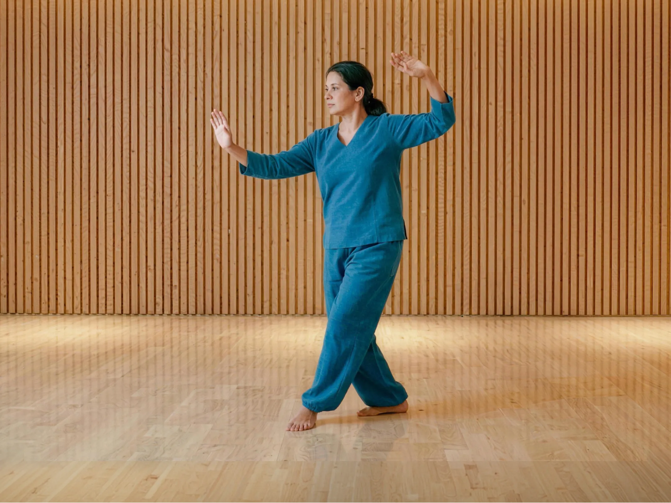 Senior man in balanced Tai Chi stance indoors