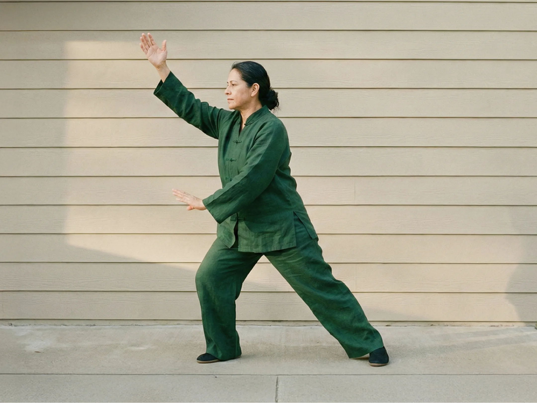 Senior man in Tai Chi stance with arms extended